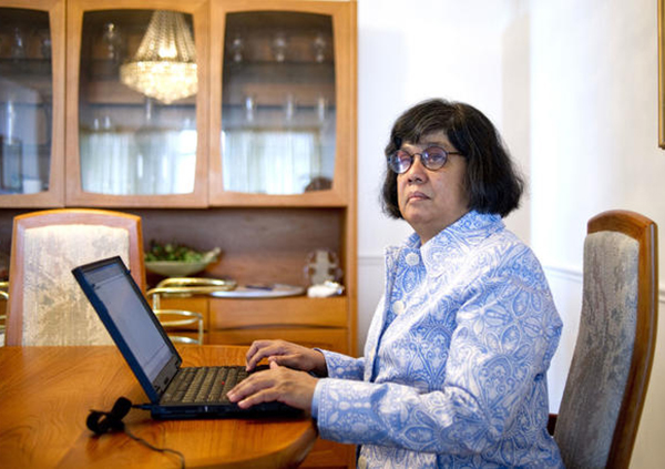 Award Winning Sight Loss Coach, Advocate and Author Donna Jodhan sits at her laptop.