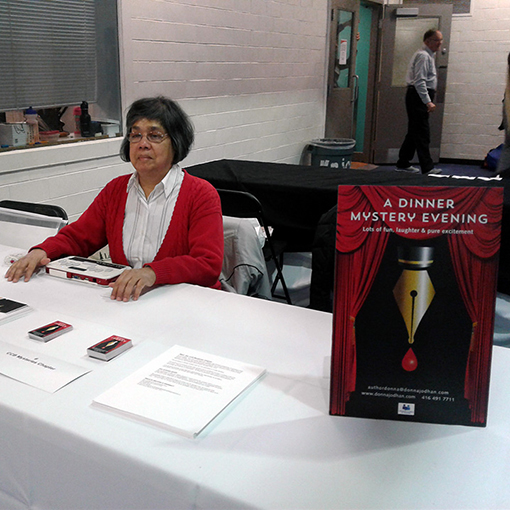 Donna Jodhan smiling while sitting at a table at one of her many Dinner Mystery Evening events.