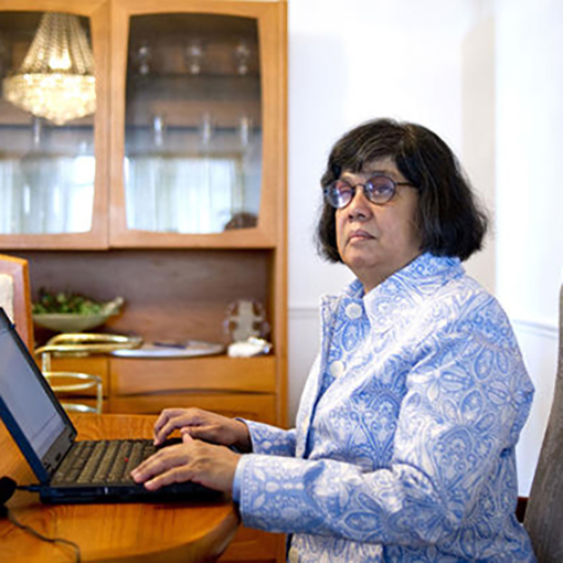Donna Jodhan sitting at a laptop writing fiction.