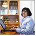 Award Winning Sight Loss Coach, Advocate and Author Donna Jodhan sits at her laptop.